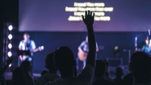 Person raising their hand in a church service.